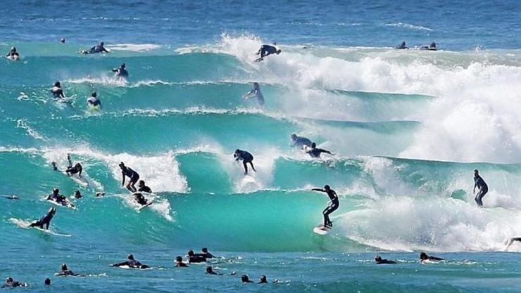 Surfers ride the Coolangatta surf breaks in Gold Coast, Queensland, Australia (Source dailytelegraph.com.au).jpg